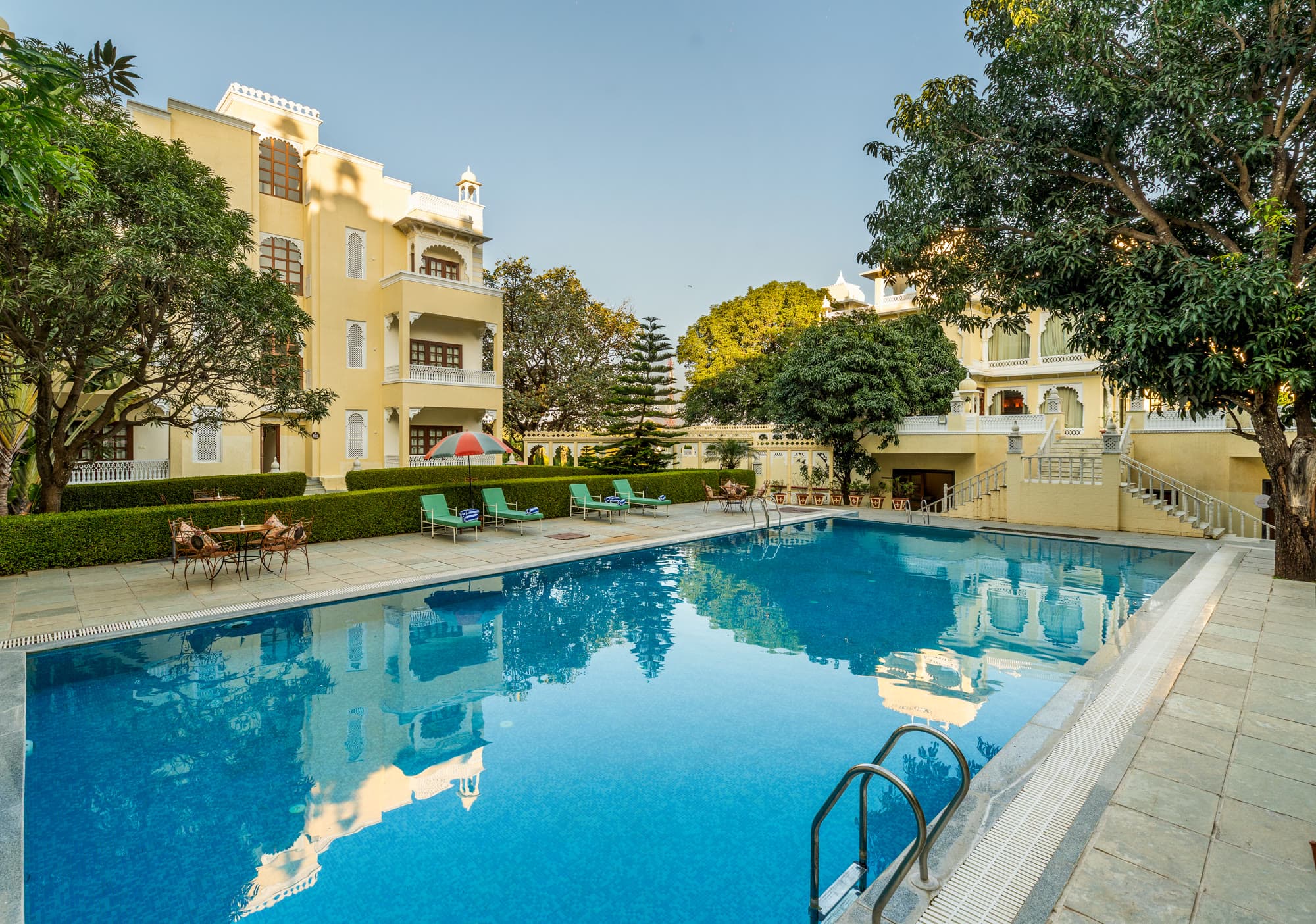 The swimming pool with sun loungers, beside the resort buildings