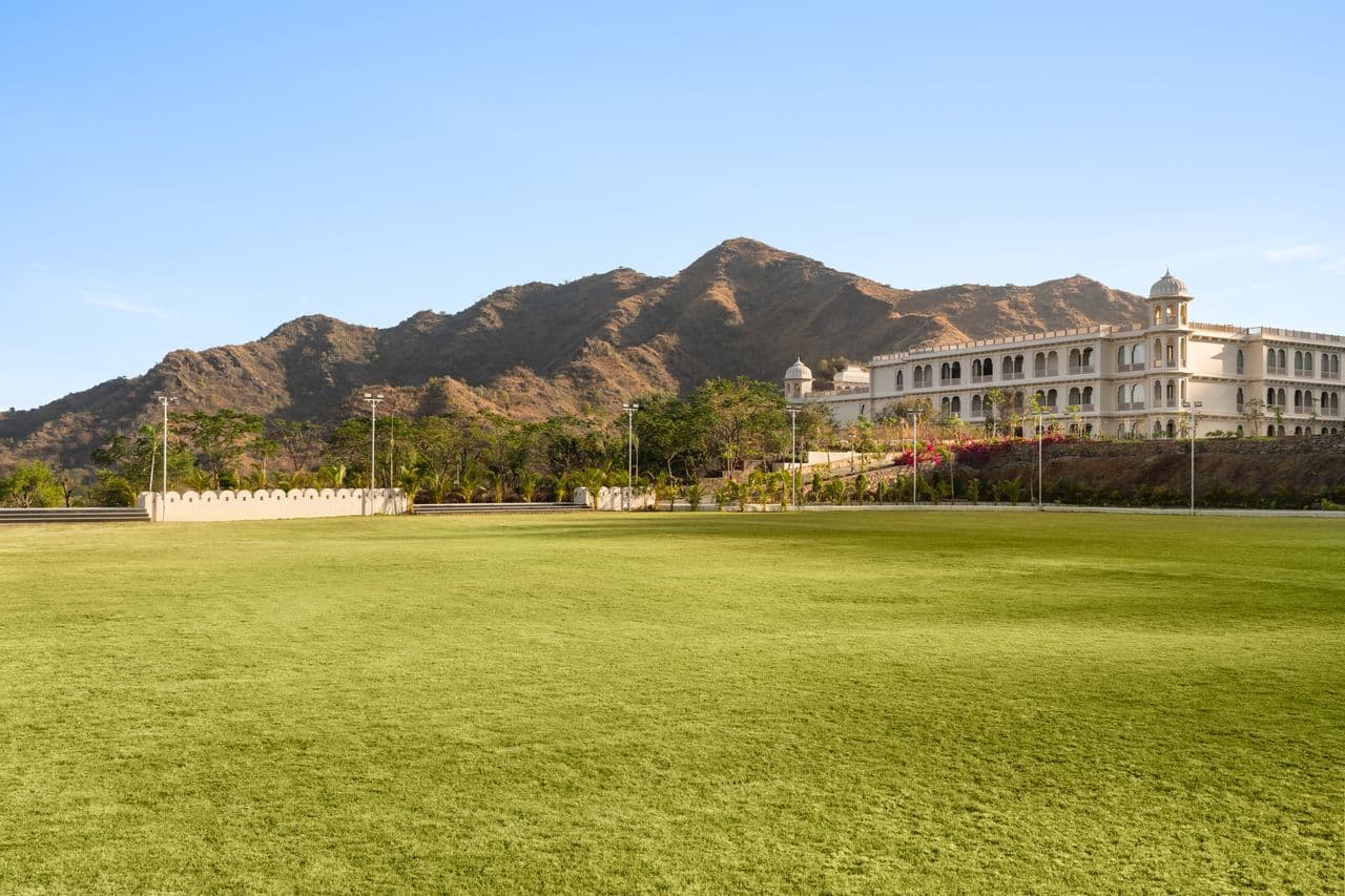 The resort building beside a wide lawn, with hills behind